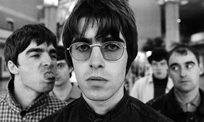 Oasis - learn songs with 1to1 lessons on guitar at Salford Guitar Lessons. Image from https://www.rollingstone.com/music/music-news/liam-gallagher-vs-noel-gallagher-oasis-brothers-beef-history-explained-206050/
